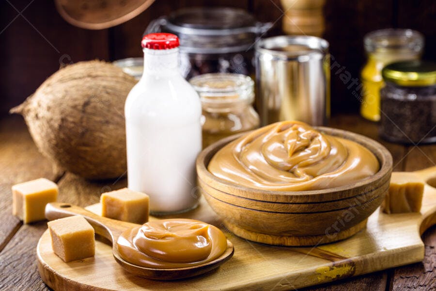 Doce de leite cremoso em tigela rústica com coco e leite fresco