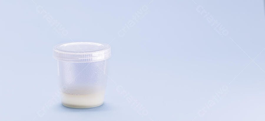 Recipiente de amostra transparente com fluido branco em fundo azul pastel