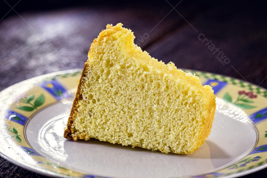 Fatia de bolo amarelo caseiro em prato decorado para lanche da tarde