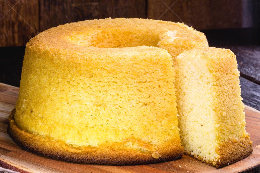 Bolo de milho caseiro fofo e amarelo em tábua de madeira rústica