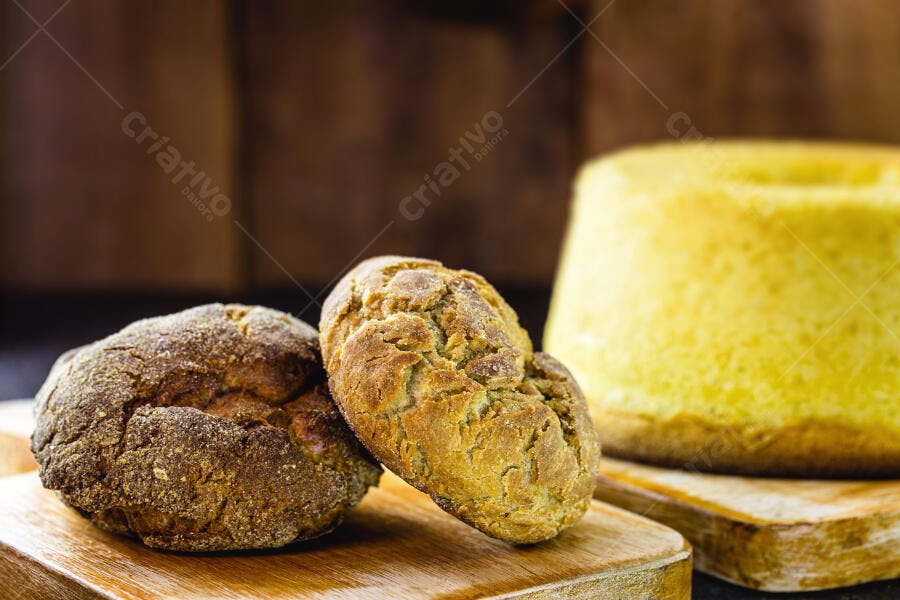 Pães e bolo de milho caseiros em tábua de madeira rústica