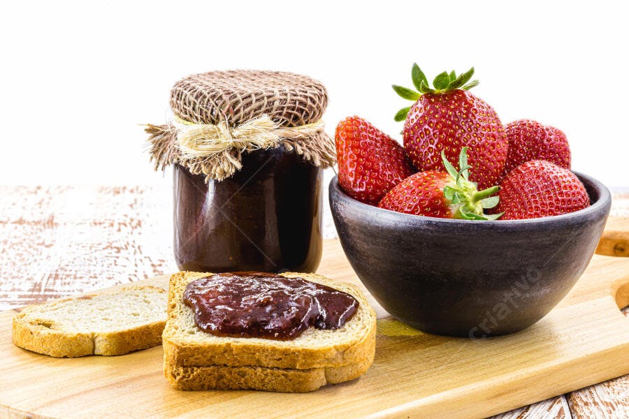 Geleia de morango caseira com pão torrado e morangos frescos para o café da manhã
