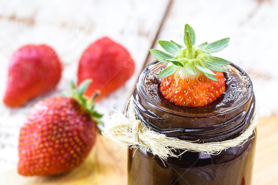 Morango fresco em pote de chocolate com barbante rústico sobre madeira clara
