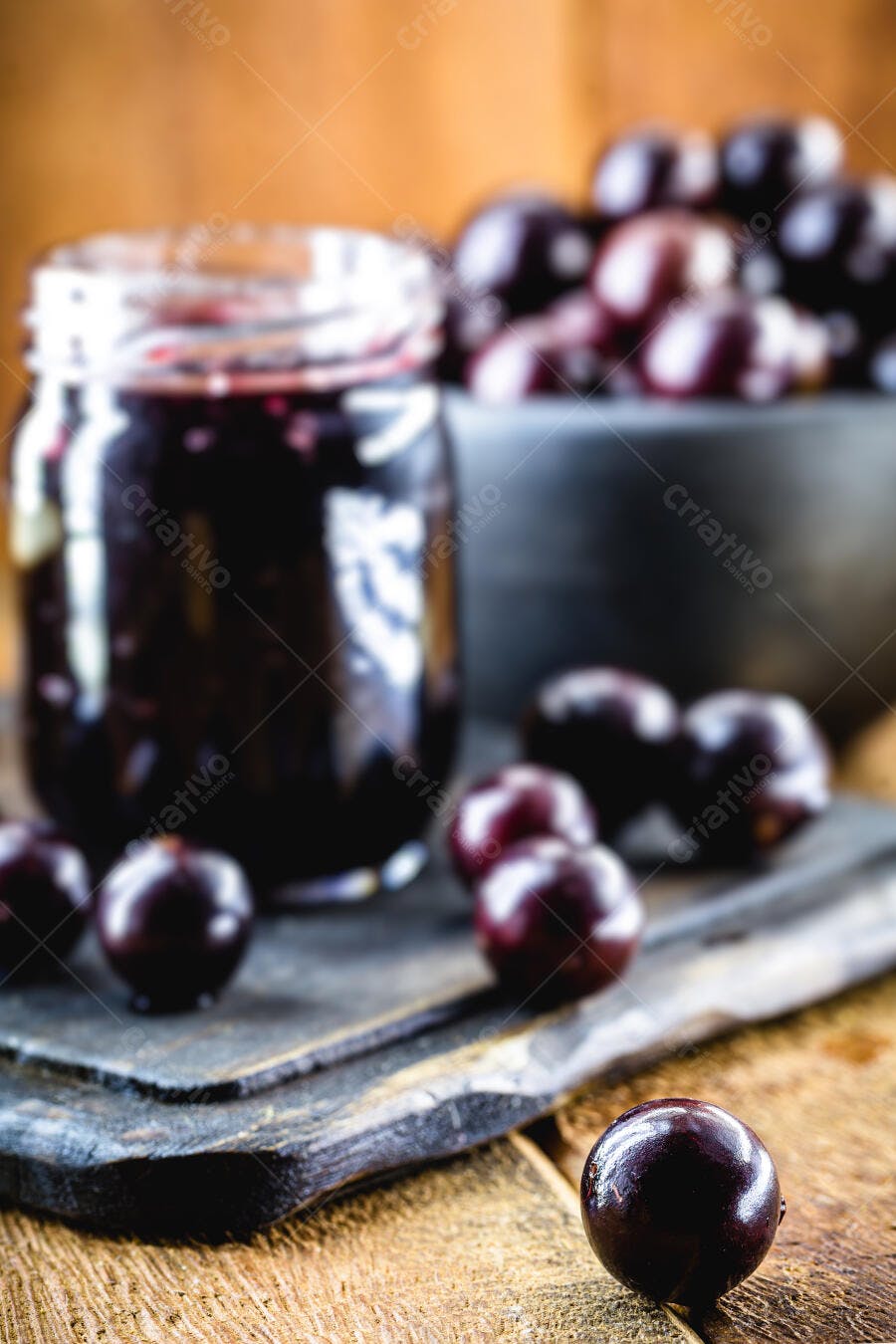 Geleia de jabuticaba em pote de vidro com frutas frescas na mesa rústica