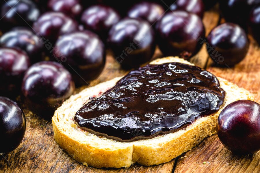 Pão com geleia de jabuticaba e frutas frescas em mesa rústica