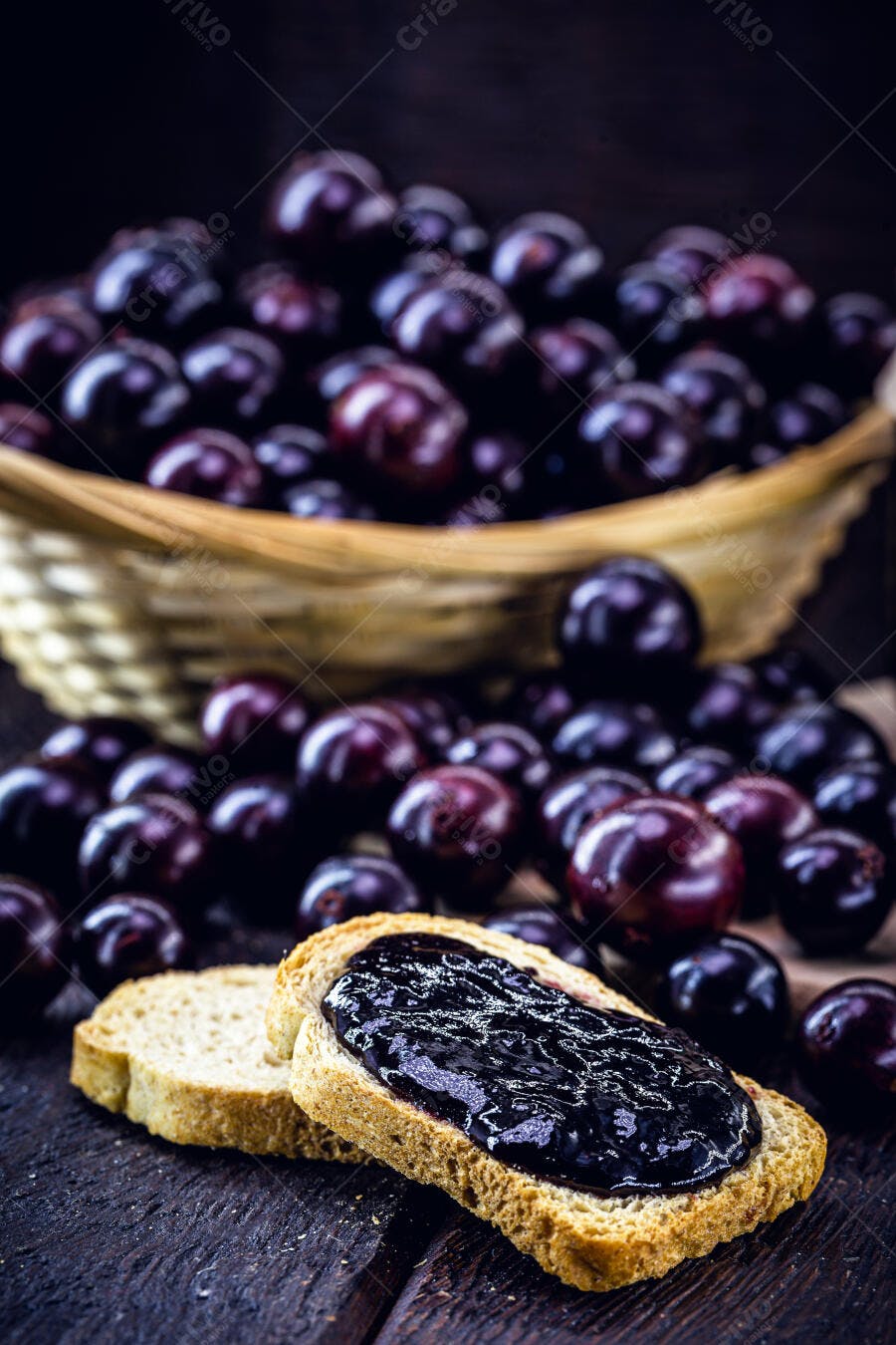Jabuticabas frescas em cesta e torrada com geleia sobre madeira rústica