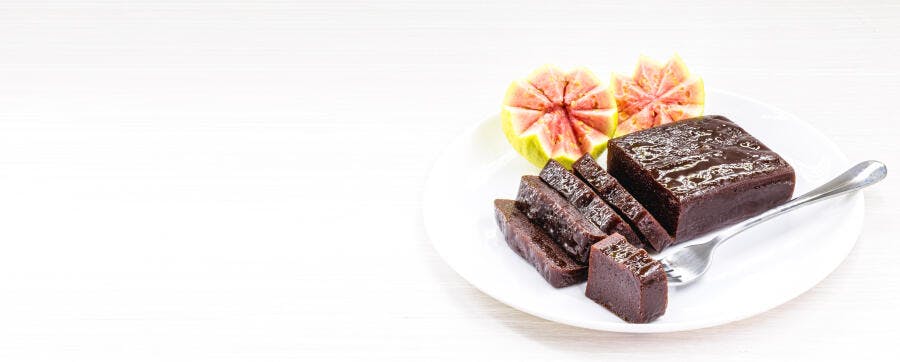 Goiabada tradicional com goiabas frescas fatiadas em prato branco