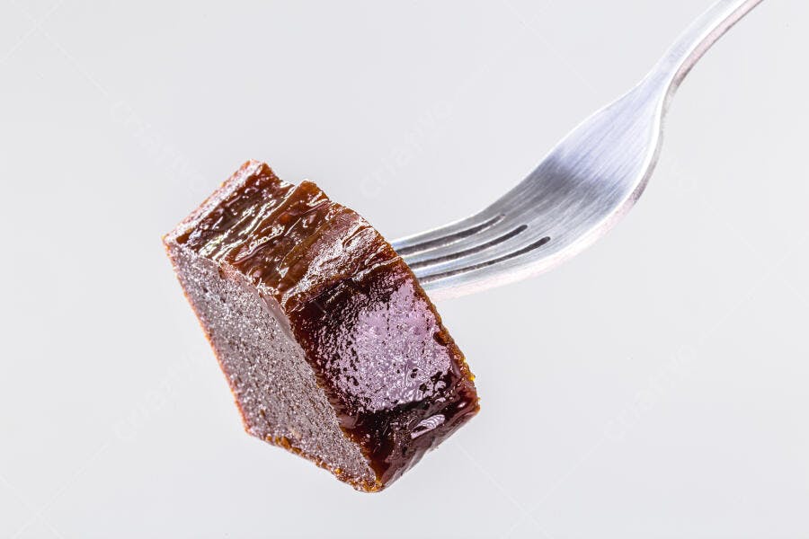 Marmelada de fruta escura com garfo em fundo branco