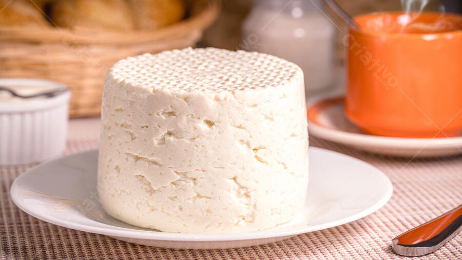 Queijo minas fresco redondo no café da manhã com pães e café