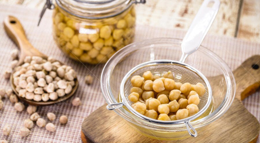 Grão de bico cozido e seco em utensílios de cozinha de madeira