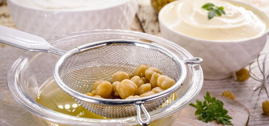 Grão de bico sendo escorrido para receita de homus saudável