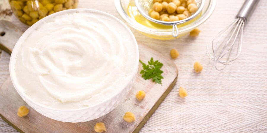 Creme branco vegano em tigela com grão de bico aquafaba e salsinha