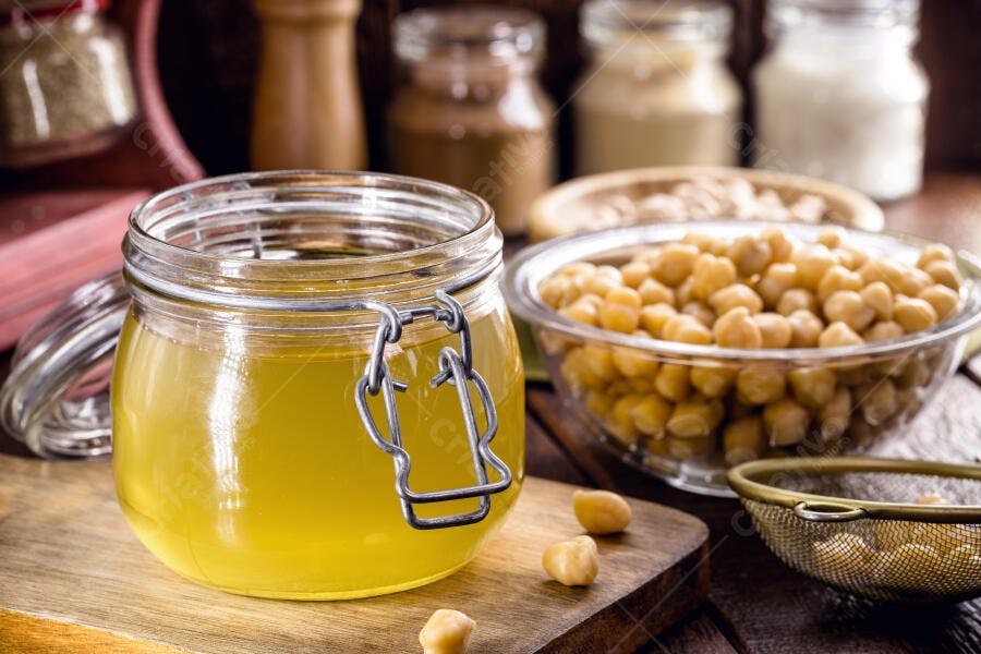 Aquafaba caseira e grão de bico ingredientes veganos em pote e tigela