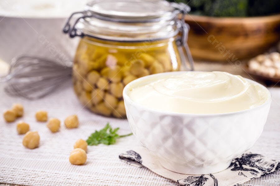 Creme branco e grão de bico em tigela e pote de vidro na cozinha
