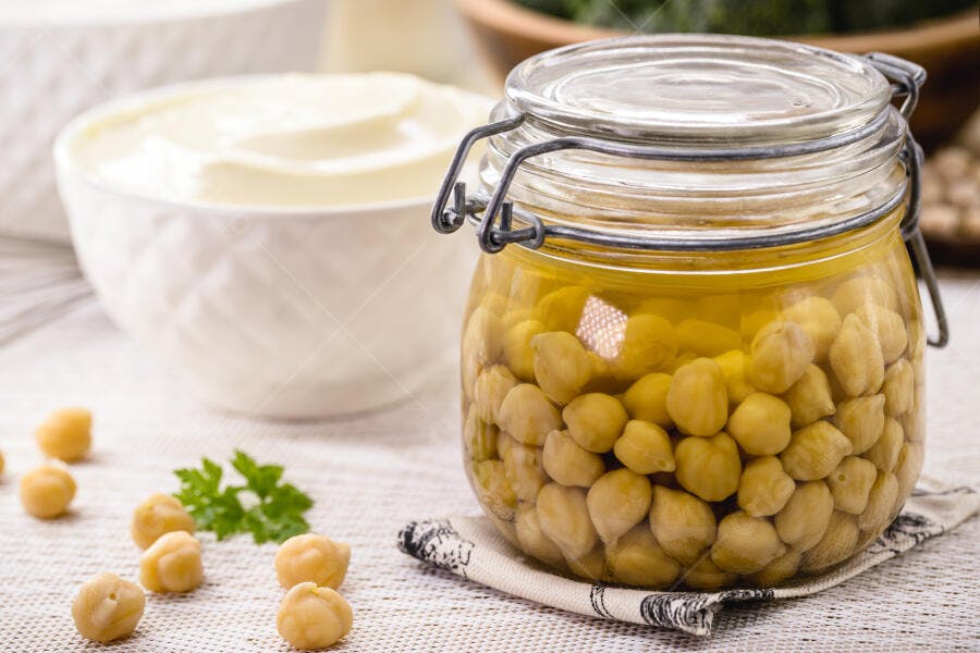 Grão de bico cozido em pote de vidro com salsa e creme branco
