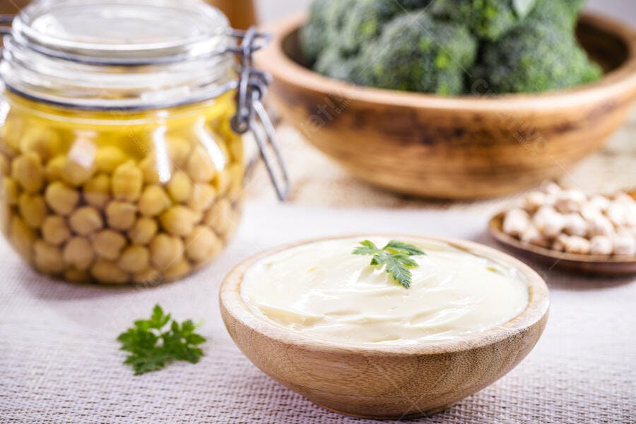 Molho de grão de bico cremoso em tigela de bambu com vegetais saudáveis