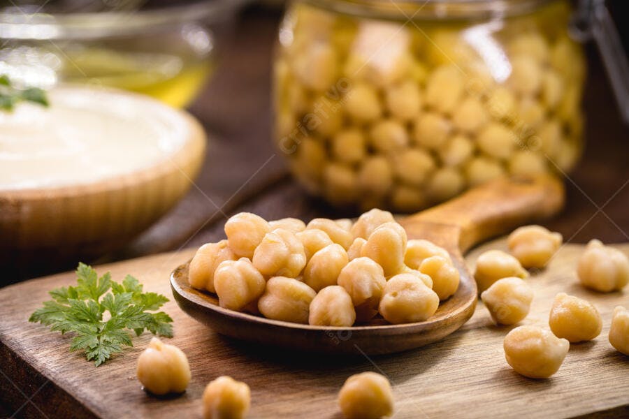 Grão de bico cozido em colher de pau com salsinha fresca e hummus