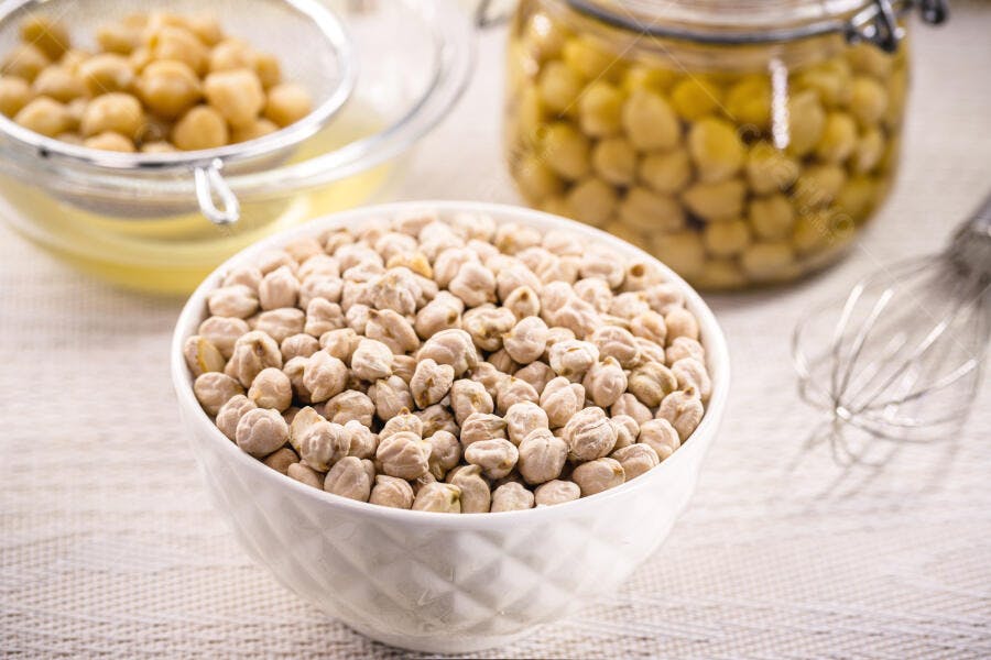 Grão-de-bico seco e cozido em tigelas para preparo saudável na cozinha
