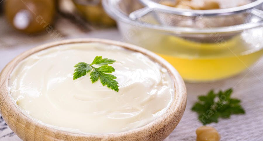 Maionese cremosa em tigela de madeira com salsinha fresca preparo culinário