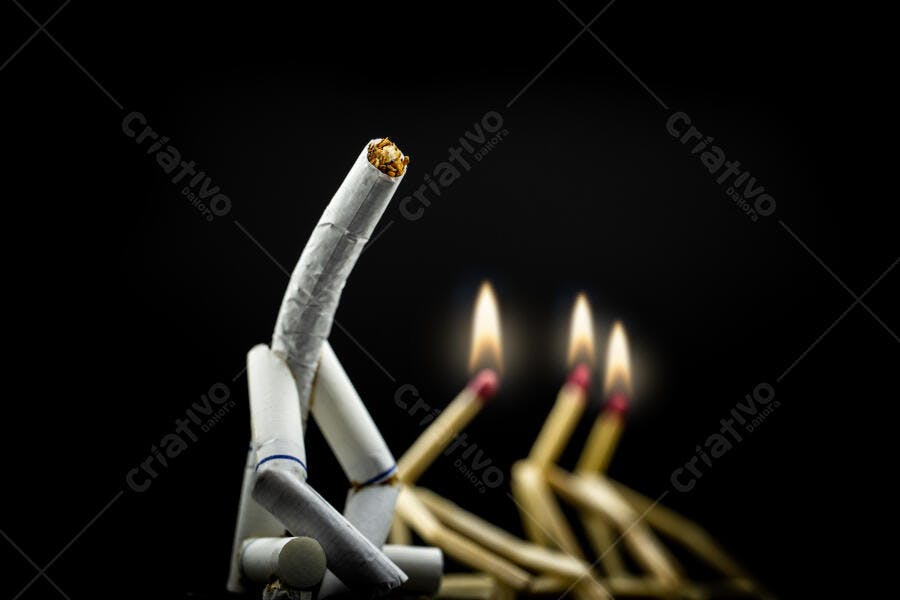 Cigarros brancos formando figura humana com fósforos acesos no escuro