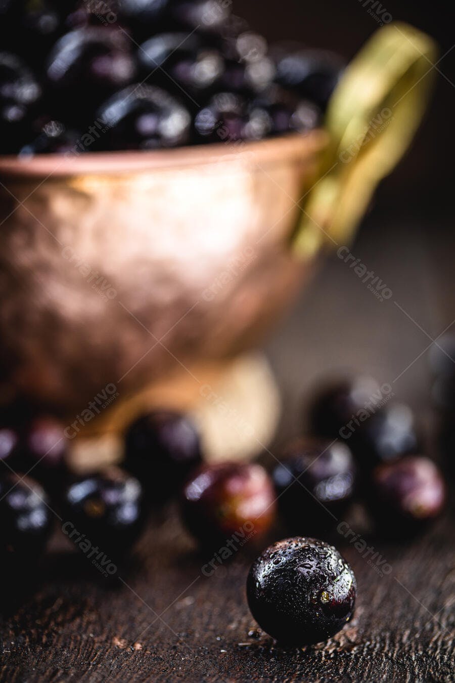 Jabuticabas frescas com gotas d'água em pote de cobre rústico