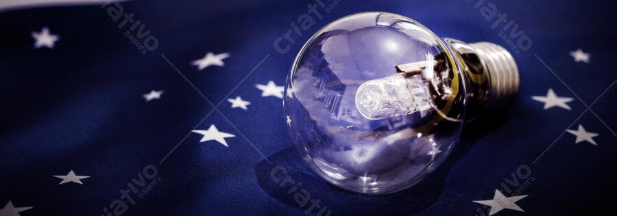 Lâmpada de vidro transparente sobre fundo azul escuro com estrelas brancas