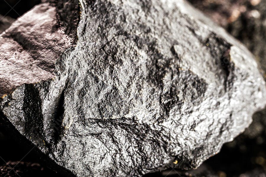 Carvão mineral bruto em close-up com textura áspera e brilho metálico