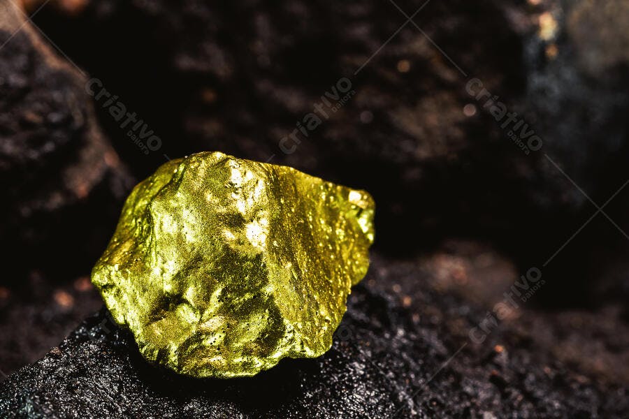 Pepita de ouro brilhante em rocha escura descoberta na mineração