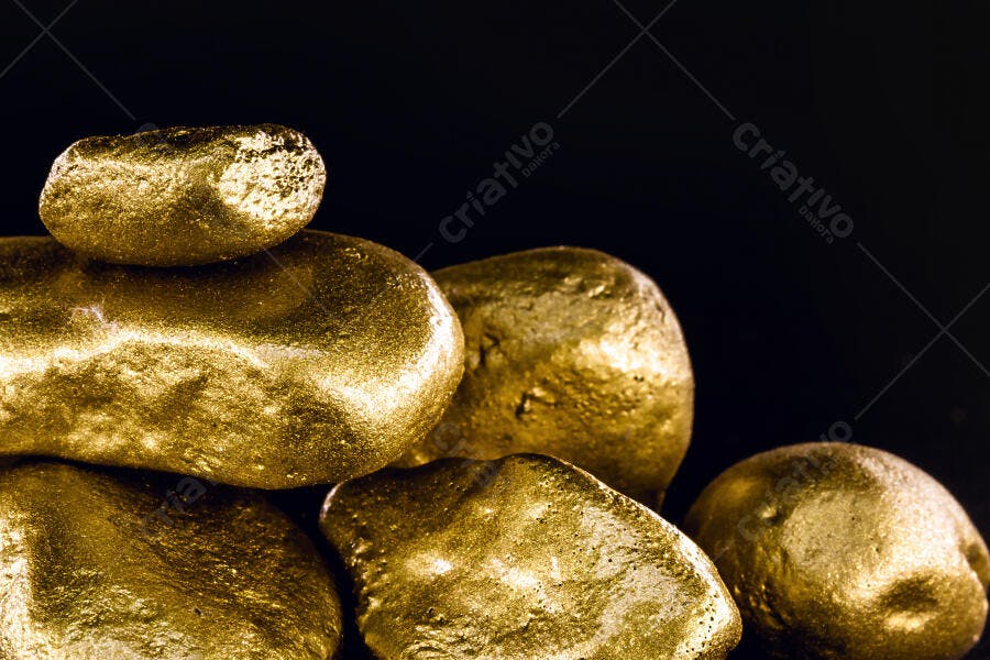 Pepitas de ouro douradas empilhadas em fundo escuro símbolo de riqueza e investimento