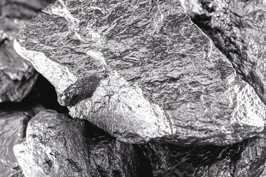 Minério escuro com superfícies metálicas e textura rugosa