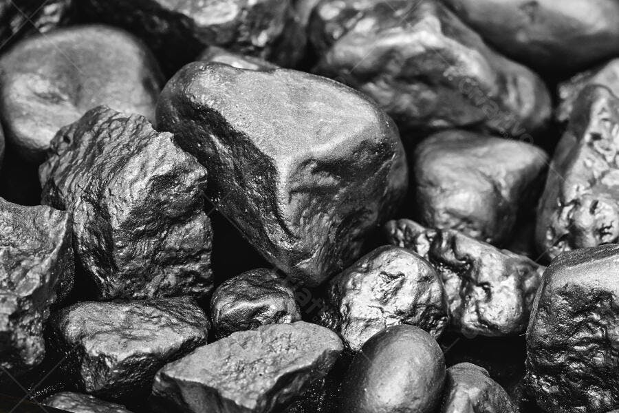 Minério bruto de metal escuro em pilha com reflexos prateados