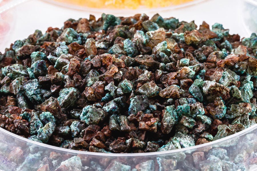 Pedras minerais azuis e marrons em recipiente transparente