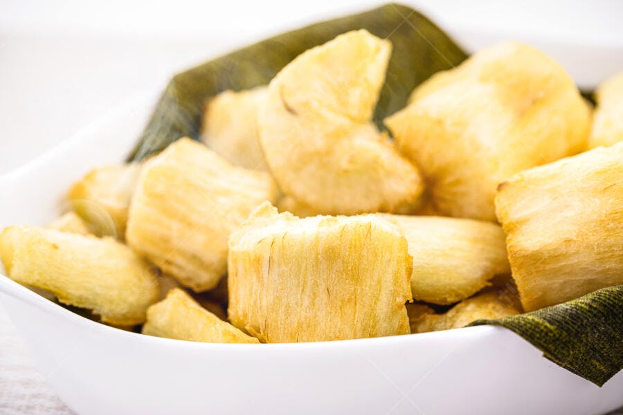 Mandioca frita dourada em tigela branca petisco saboroso