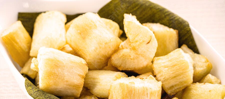 Mandioca frita crocante em tigela branca com guardanapo verde