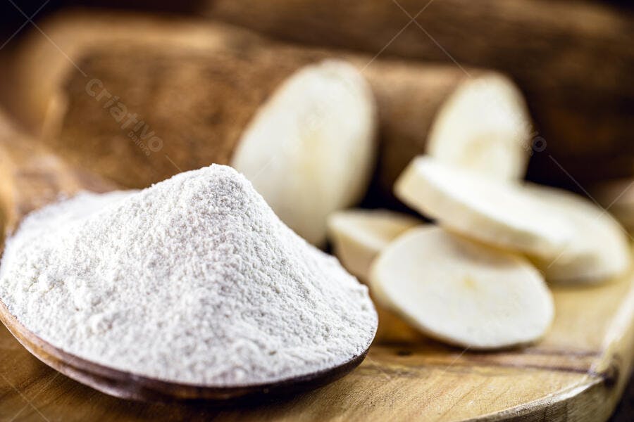 Farinha de tapioca mandioca branca em colher de pau rústica e rodelas
