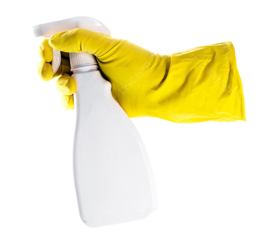 Mão com luva amarela segurando borrifador branco para limpeza