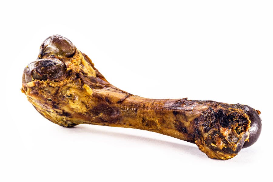 Osso de pernil de porco assado dourado e marrom em fundo branco
