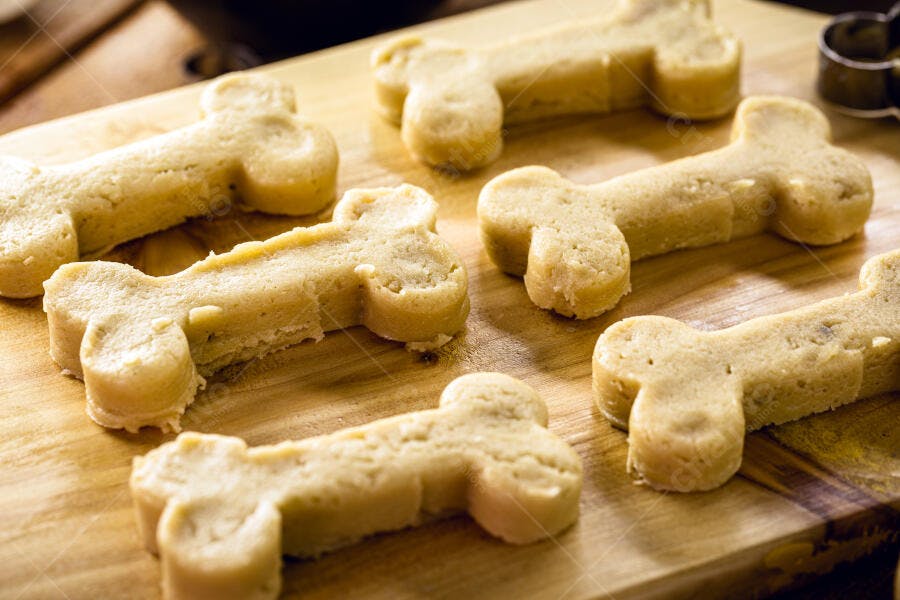 Petiscos de cachorro caseiros em formato de osso na tábua de madeira