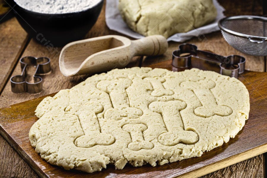 Massa de biscoito em formato de osso para pets na tábua de madeira