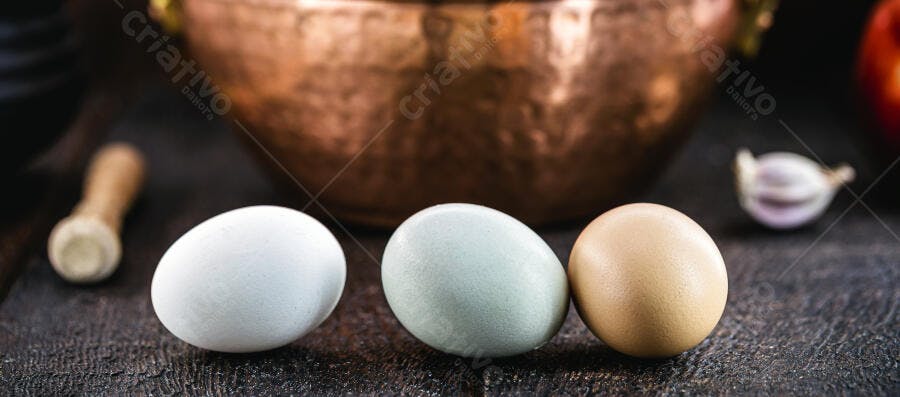 Três ovos coloridos de galinha caipira em bancada rústica na cozinha