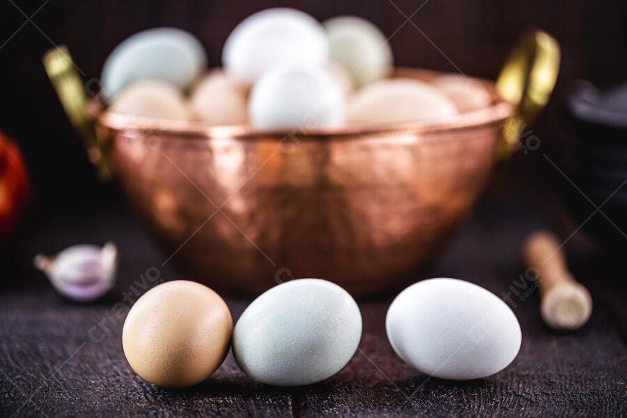 Ovos frescos de cores variadas em mesa rústica com panela de cobre