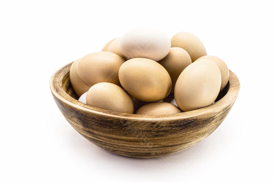 Ovos caipiras marrons e brancos em tigela de madeira rústica