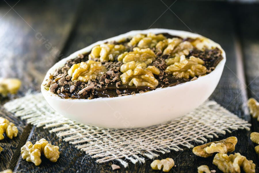 Ovo de Páscoa de colher com brigadeiro nozes e granulado em fundo rústico