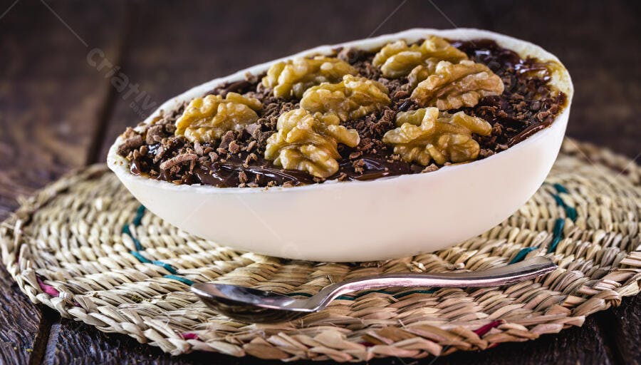 Ovo de Páscoa recheado com chocolate e nozes em mesa rústica de madeira