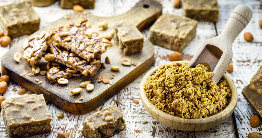 Doces de amendoim brasileiros paçoca e pé de moleque em mesa rústica