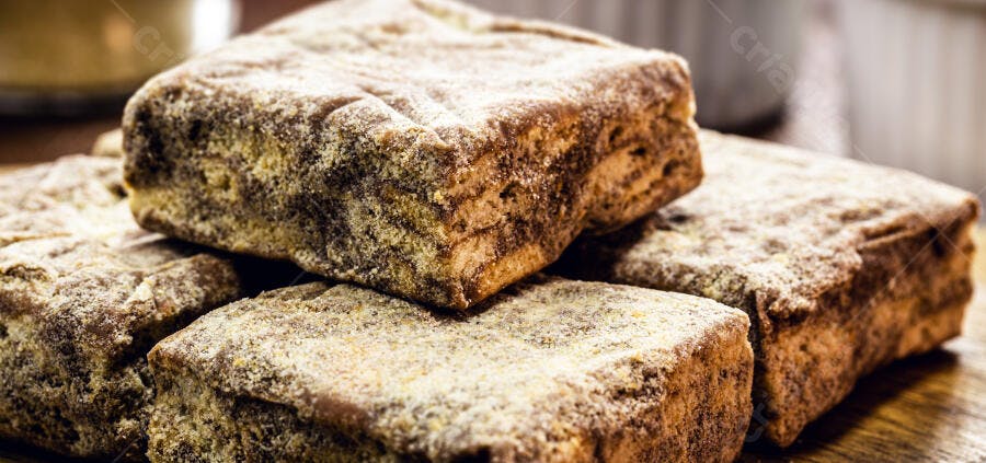 Doces quadrados rústicos polvilhados com açúcar em close-up apetitoso