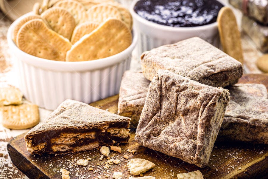Palha italiana de chocolate com biscoitos e raspas em tábua de madeira