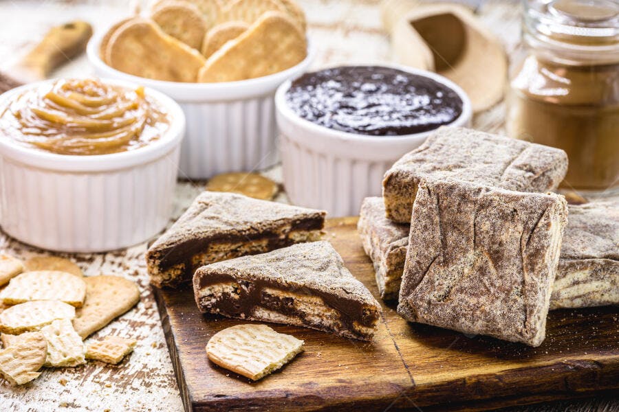 Doces brasileiros Palha italiana doce de leite e biscoitos em mesa rústica