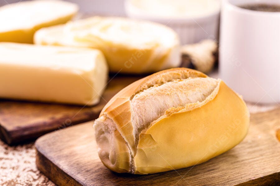 Pão francês crocante com manteiga e café no café da manhã