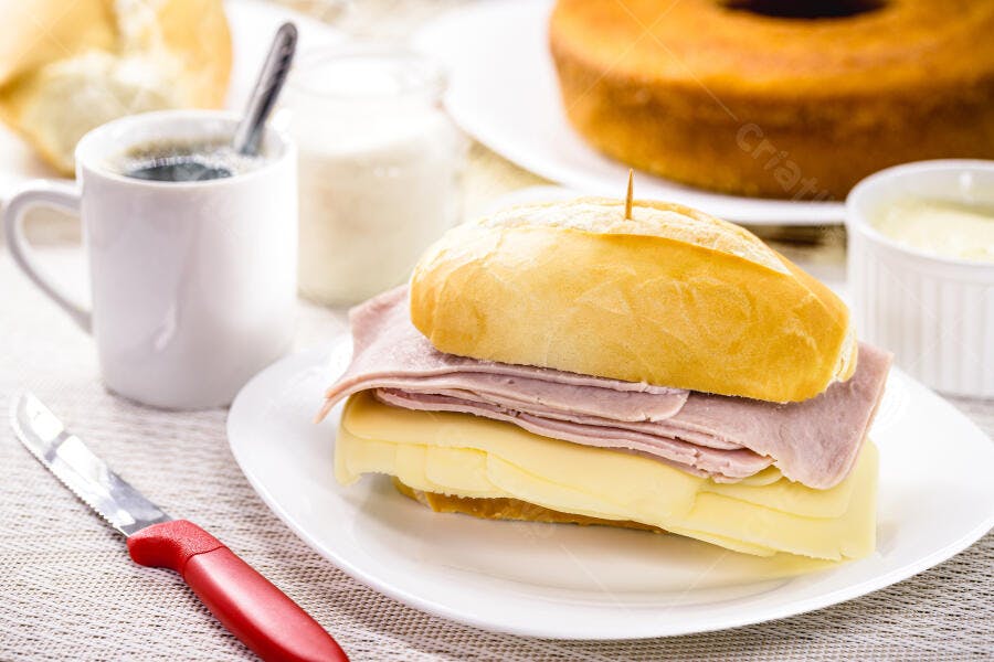 Sanduíche de queijo e presunto com café fresco e bolo de café da manhã